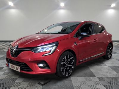 a red car is parked on a checkered floor in a garage