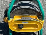 un chariot à tuyaux d'incendie jaune et vert, équipé de tuyaux