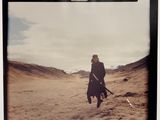 a polaroid picture of a man walking in the desert