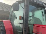 un tracteur rouge garé devant une maison