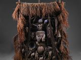 une sculpture représentant un homme dans une hutte, entouré de nombreux objets