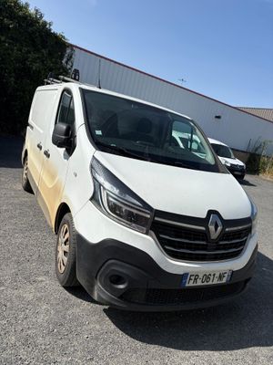 the white van is parked in a parking lot near a building
