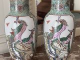 two vases sitting on a table with a mirror in the background