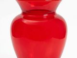un vase en verre rouge muni d'un couvercle, sur fond blanc