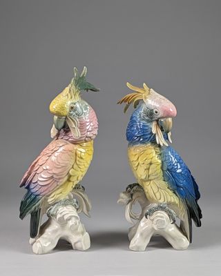 deux figurines représentant des perroquets perchés sur une branche d'arbre