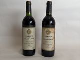 two bottles of wine sitting next to each other on a table