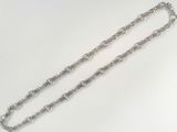 a close up of a silver chain on a white surface