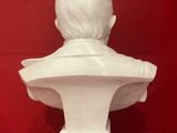 white marble bust of a child on a red background