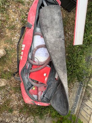 a red duffel bag filled with items sitting on the ground