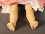 a close up of a doll with a pink dress on