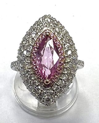 an image of a pink and white diamond ring sitting on top of a clear stand