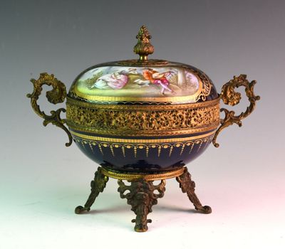 a blue and gold bowl with a lid on a stand