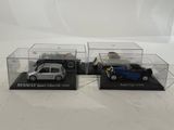 two model cars in clear cases on a white surface