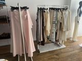 a rack of clothes in a clothing store with clothes hanging on it