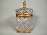 a glass jar with a gold lid sitting on a table