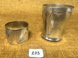 deux tasses en argent posées l'une à côté de l'autre sur une table