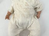 a baby doll that is laying down on a white surface