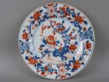une assiette bleue et rouge décorée de fleurs