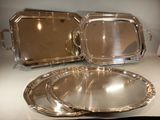 deux plateaux en argent posés sur une table blanche
