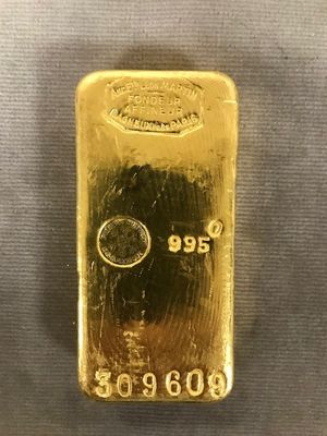 un lingot d'or posé sur une table, sur fond blanc