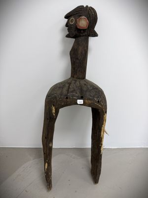 a wooden sculpture of a bird sitting on a chair