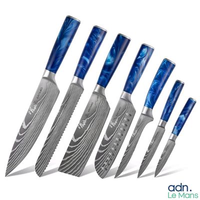 six knives are lined up in a row on a white surface