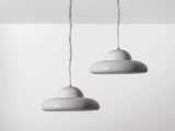 deux suspensions blanches suspendues au plafond d'une pièce blanche