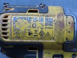 a close up of a yellow drill on a blue surface