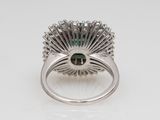 a close up of a ring with a green stone in it