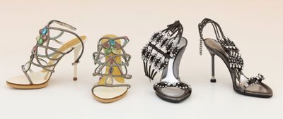 three pairs of women ' s high heeled shoes are lined up on a white surface