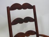 a wooden chair with a moustache on the back of it