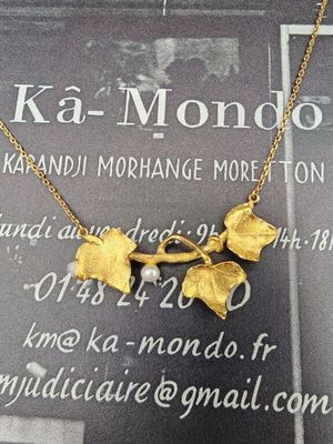 une photo d'un collier en or orné de feuilles