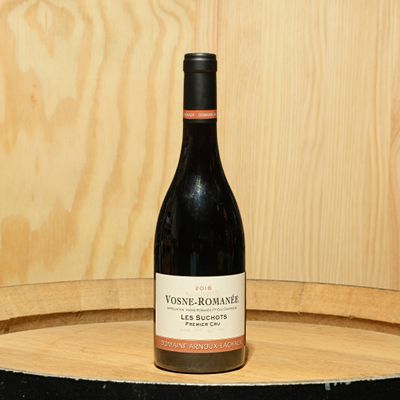 a bottle of wine sitting on top of a barrel