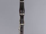 a close up of a clarinet on a clear surface with a gray background