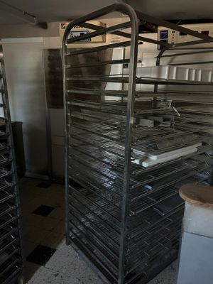 many trays of food that are on a rack in the kitchen