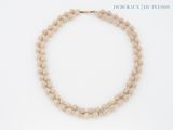 necklace made of natural stone beads with a gold clasp on a white background
