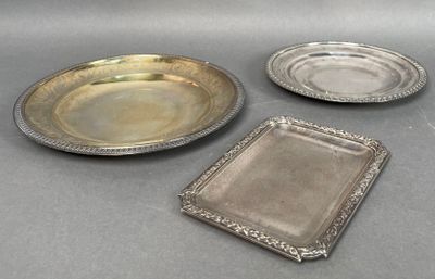 three silver plates and a silver tray on a table