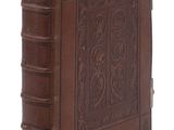 un vieux livre relié en cuir dont la couverture est ornée d'un motif décoratif