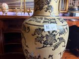 a large vase sitting on a table in front of a painting