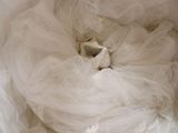 a white teddy bear in a white dress in a white bag