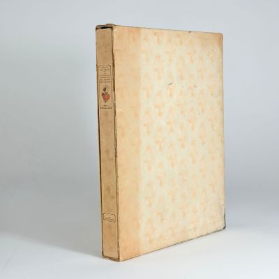 an old book sitting on top of a white table next to a white wall