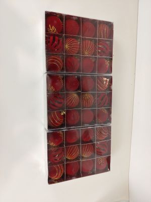 une photo d'une photo représentant une décoration de Noël rouge et dorée accrochée à un mur