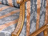 a gold and blue striped couch with a gold frame