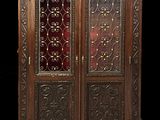 an antique wooden cabinet with a glass door and ornate carvings