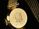 a close up of a gold watch with a black background