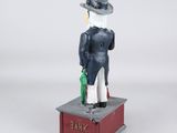 figurine of a man with a top hat and a cane standing on top of a box