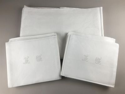 three white napkins with embroidered monograms on them on a table
