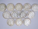 plusieurs types de pièces de monnaie sont disposés sur une surface blanche