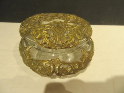 une boîte en verre ornée de motifs dorés, posée sur une table