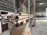 de nombreux rouleaux de bois posés sur une palette dans un entrepôt